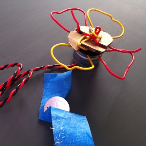 Red and yellow wires form a flower mounted to a small motor